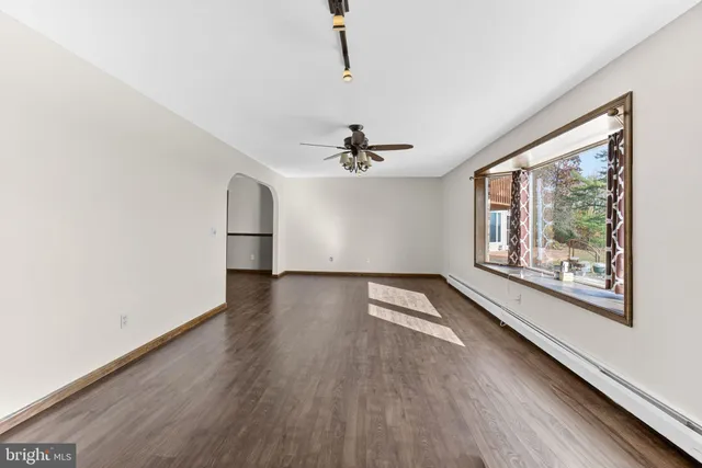 an empty room with windows and fan