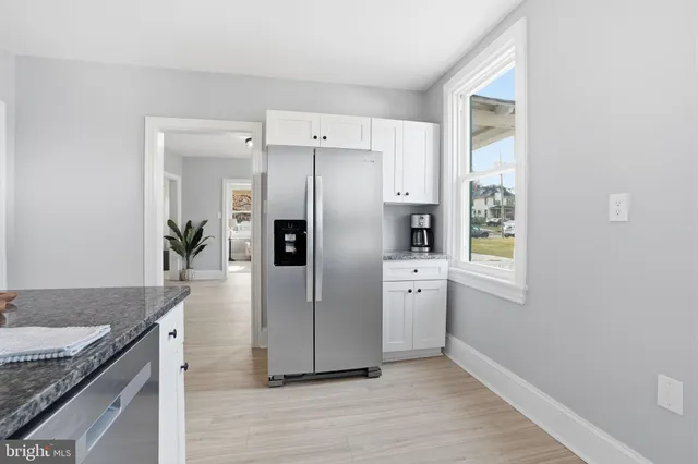 a kitchen with granite countertop a sink and a refrigerator