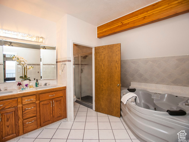 588 Raspberry Patch Road Garden City, UT 84028 - Photo 39 of 74 Full bathroom with double vanity, light tile patterned floors, a shower stall, a tub with jets, and tile walls