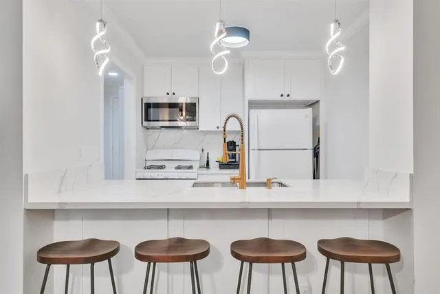 a kitchen with stainless steel appliances a sink cabinets and a refrigerator