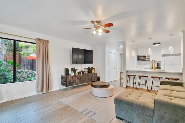 a living room with furniture a flat screen tv and a large window