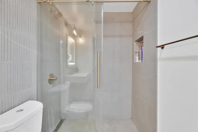 a bathroom with a toilet and a shower