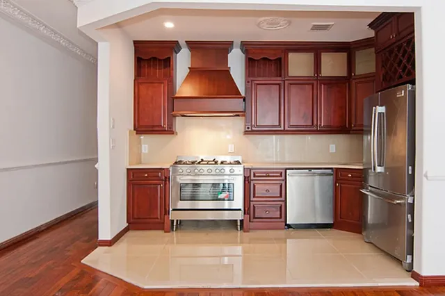 a kitchen with stainless steel appliances granite countertop a stove a sink and a refrigerator