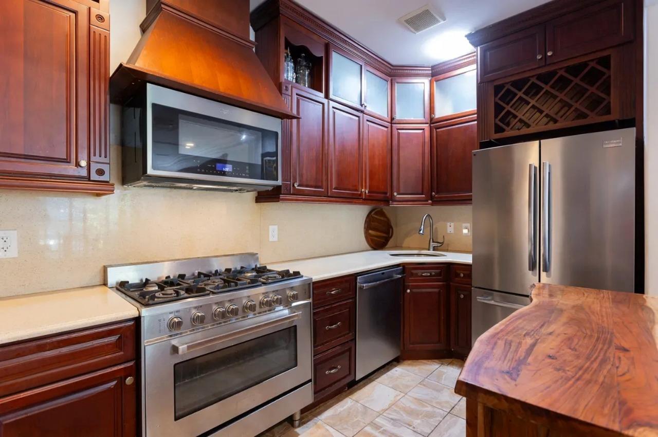 475 West 146th Street Manhattan, NY 10031 - Photo 4 of 19 a kitchen with stainless steel appliances granite countertop a stove a sink and a microwave