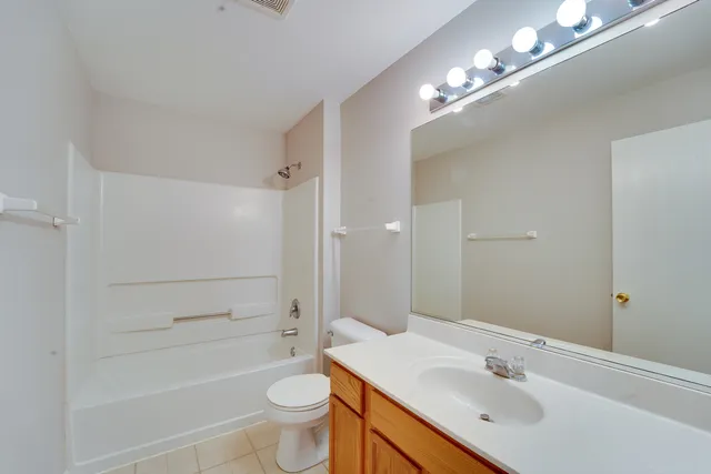 a bathroom with a sink a toilet a mirror and shower