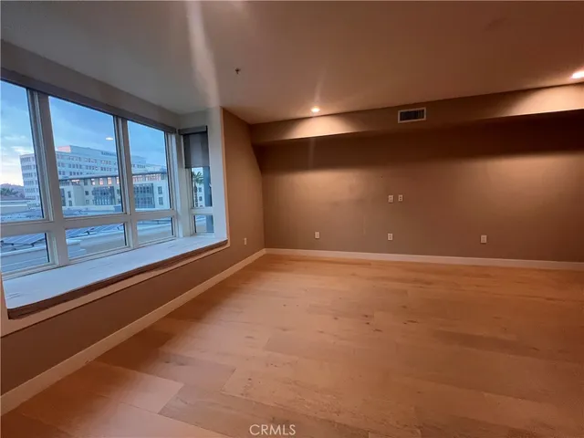 an empty room with wooden floor and a fireplace