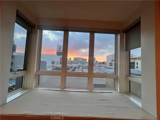 a view of a living room with a large window and wooden floor