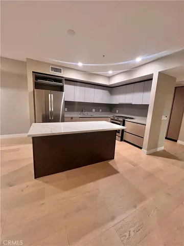 a kitchen with stainless steel appliances a sink stove and cabinets