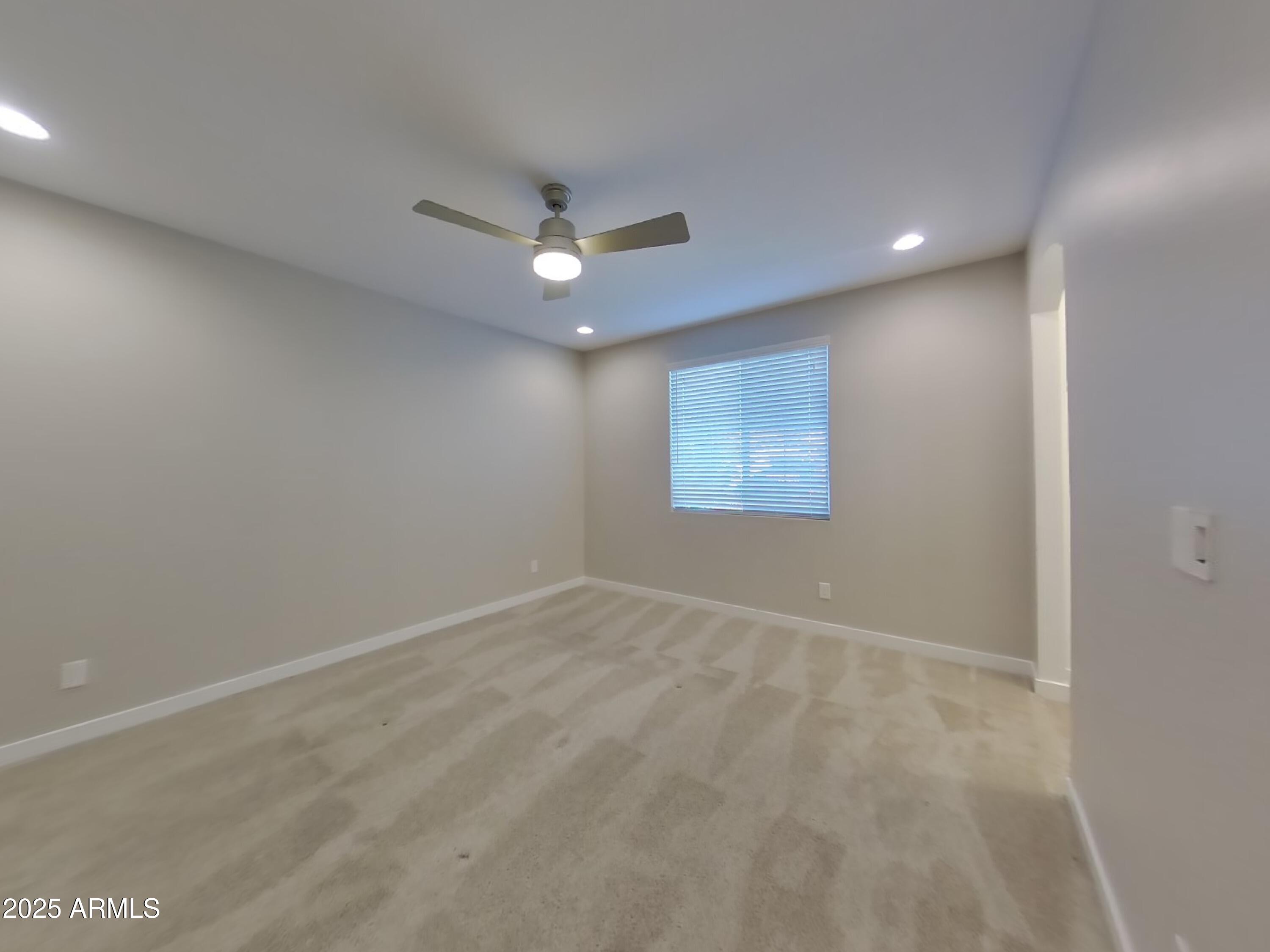 9314 East Strobe Avenue Mesa, AZ 85212 - Photo 11 of 27 an empty room with a ceiling fan and window