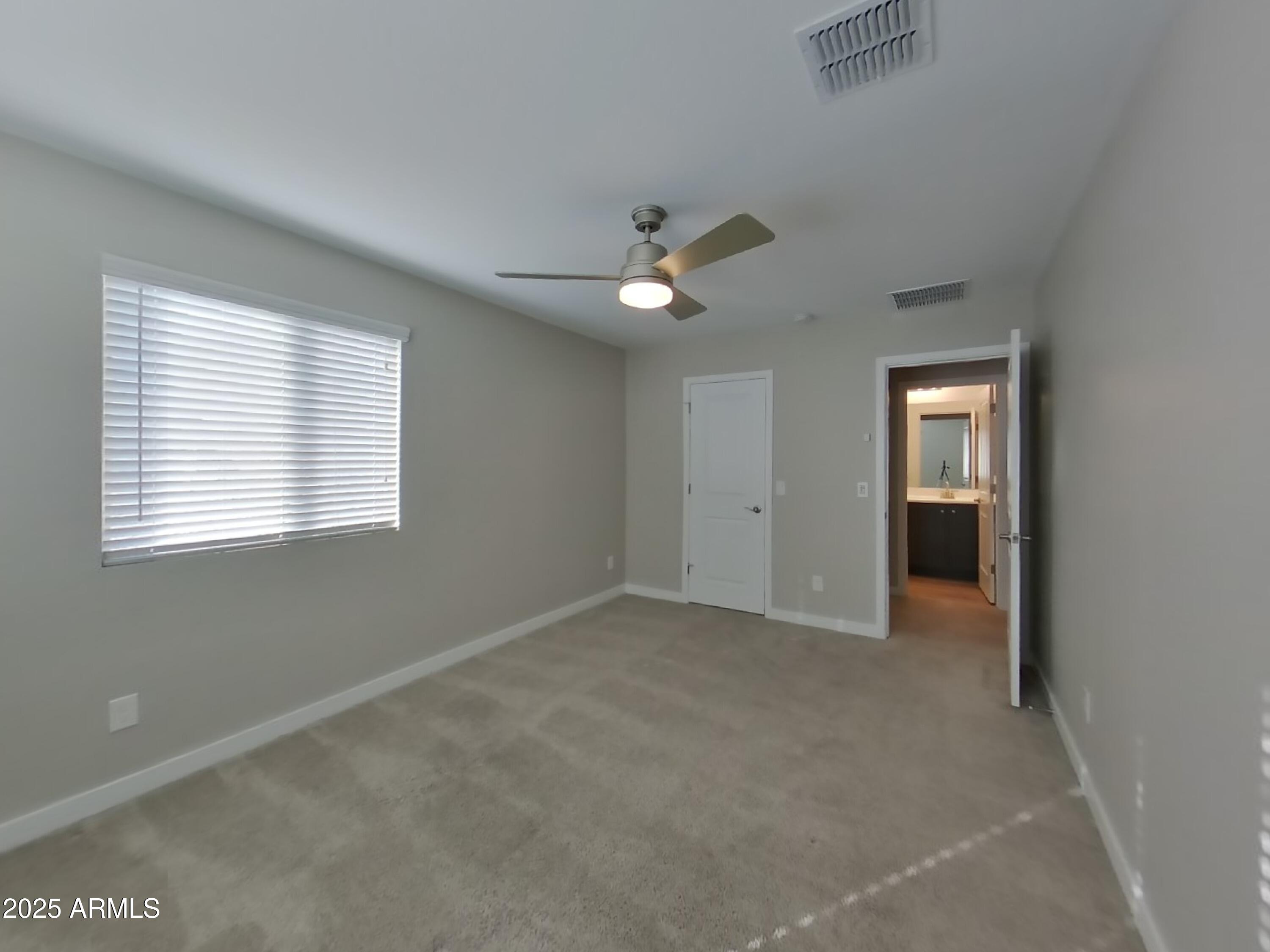 9314 East Strobe Avenue Mesa, AZ 85212 - Photo 14 of 27 an empty room with a window and a ceiling fan