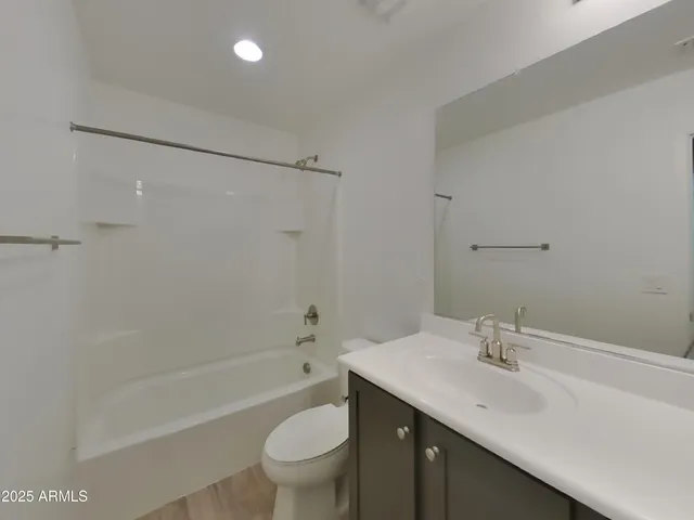 an empty room with a ceiling fan and bathroom