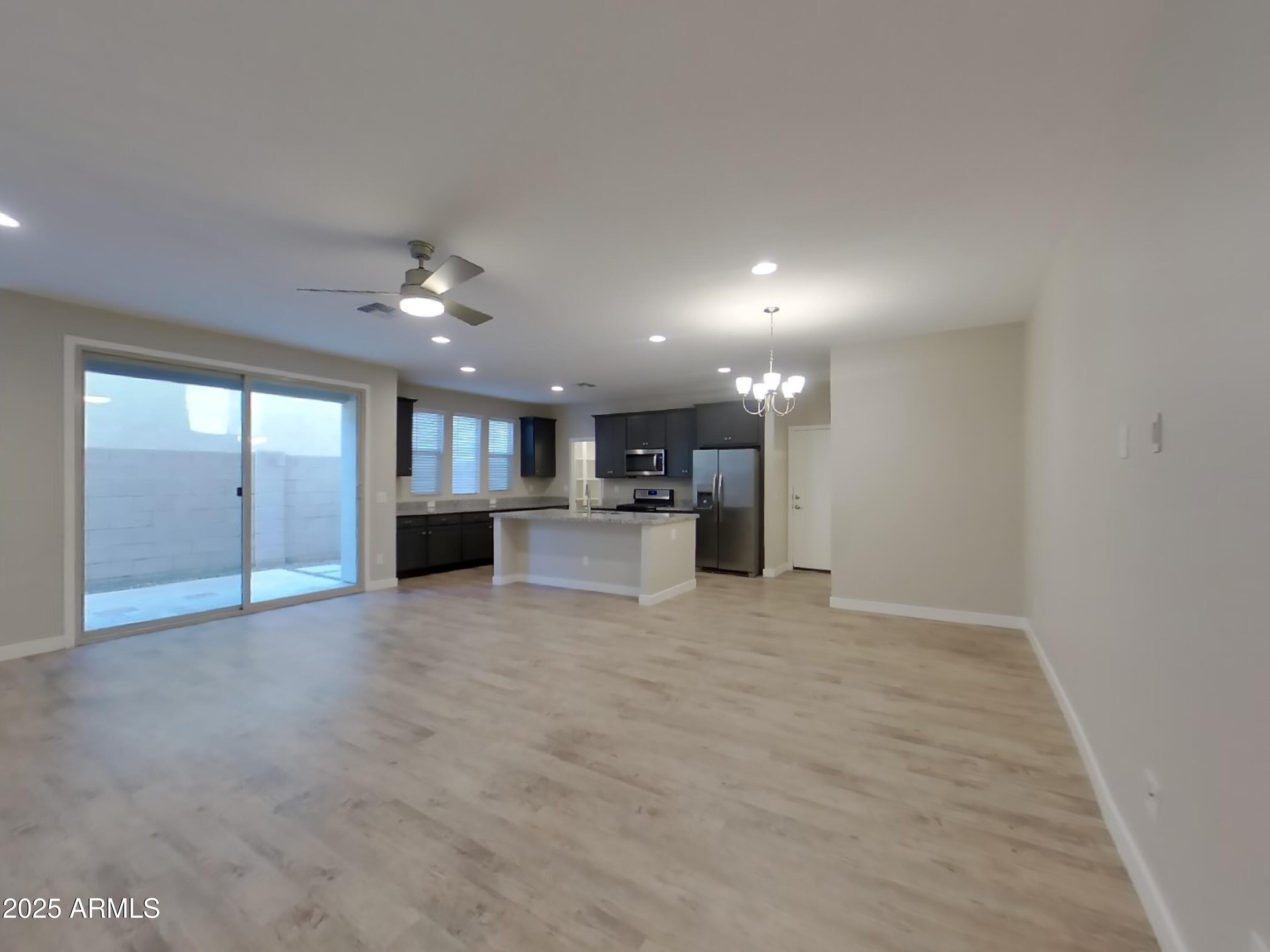 9314 East Strobe Avenue Mesa, AZ 85212 - Photo 4 of 27 a view of an empty room with kitchen and window