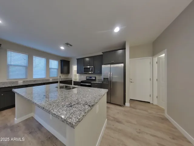 a view of an empty room and kitchen view