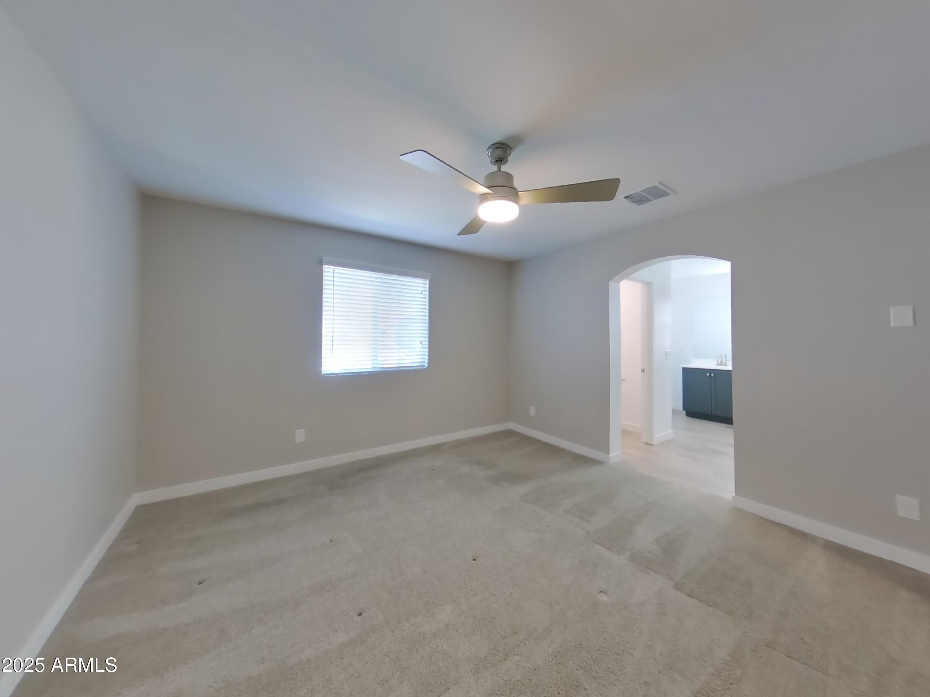 9314 East Strobe Avenue Mesa, AZ 85212 - Photo 8 of 27 an empty room with a window and a fan