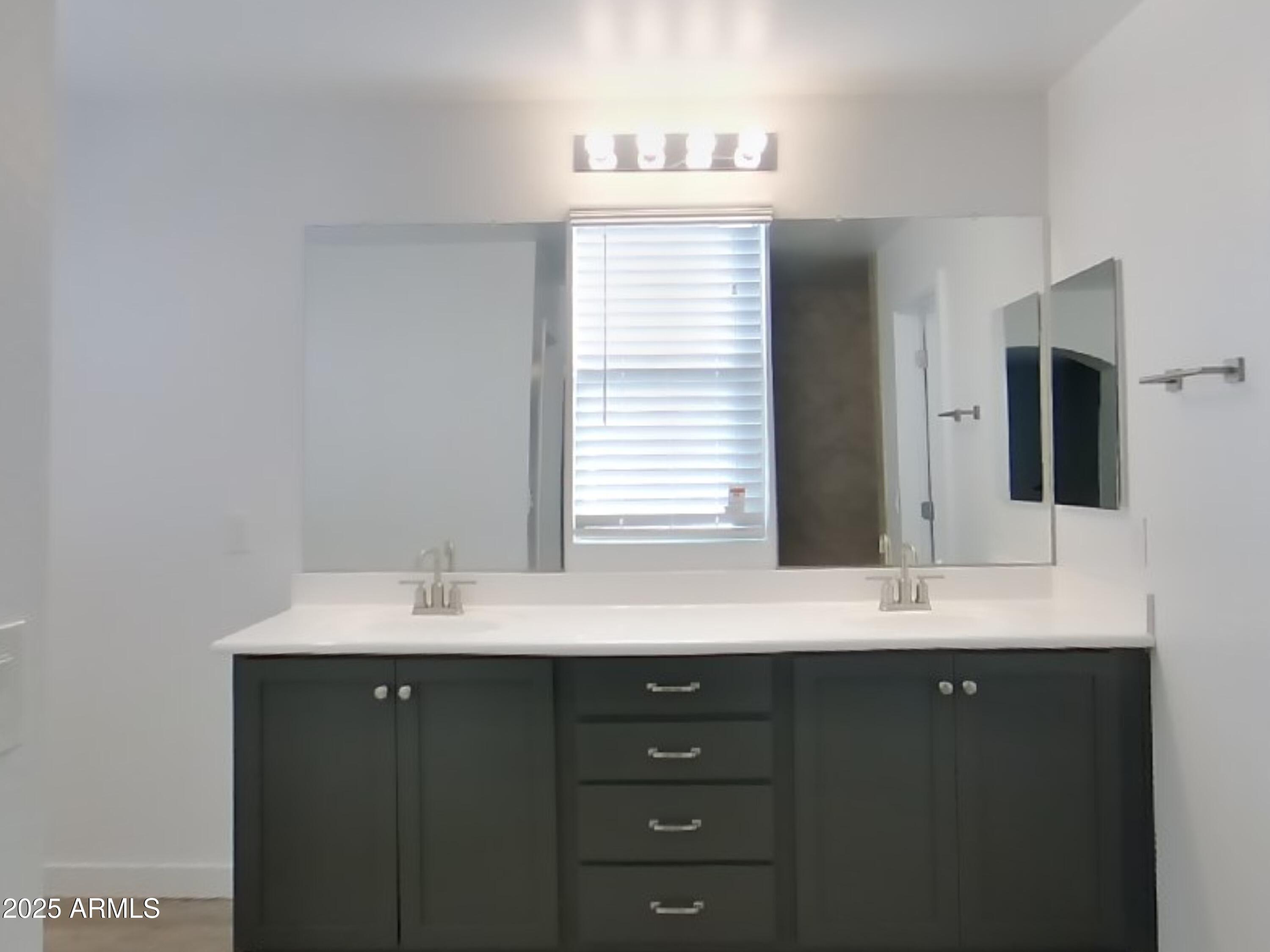 9314 East Strobe Avenue Mesa, AZ 85212 - Photo 9 of 27 a bathroom with a granite countertop sink and a mirror