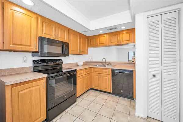 a kitchen with a sink a stove top oven and cabinetry