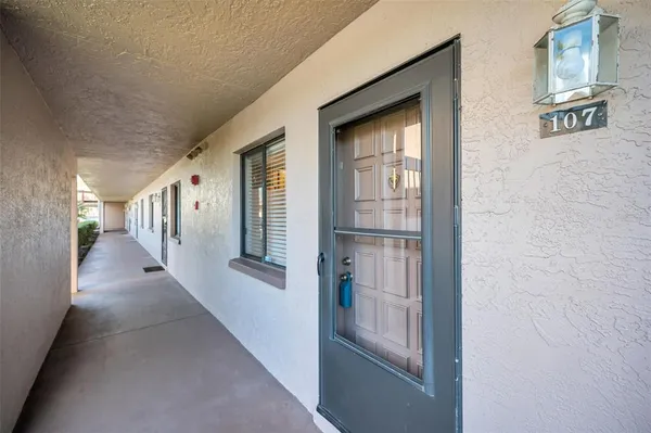 a view of an empty room with wooden floor and windows