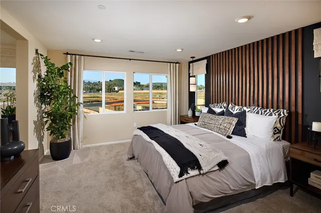 a bed sitting in a spacious bedroom next to a window