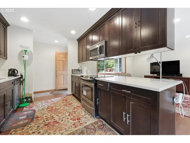 a kitchen with granite countertop stainless steel appliances lots of counter top space cabinets and a sink
