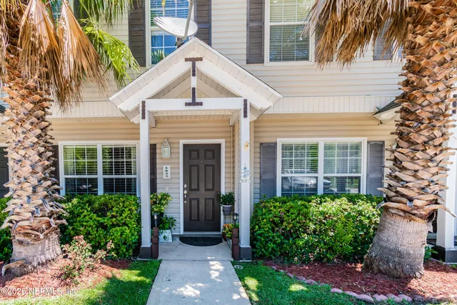 a view of a house with brick walls and a yard with plants and a table and chairs