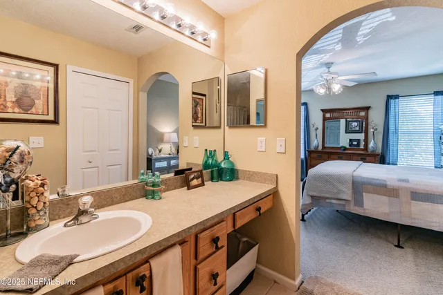 a en suite bathroom with a granite countertop sink and a mirror