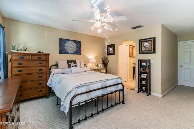 a bedroom with a bed and a lamp on dresser
