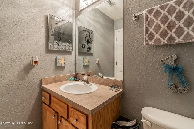 a bathroom with a sink toilet and a mirror