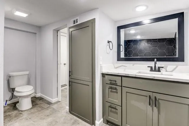 a bathroom with a toilet sink and mirror