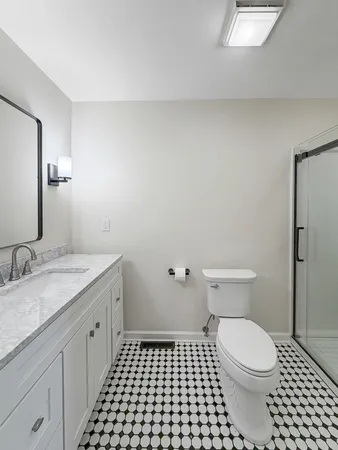 a bathroom with a granite countertop toilet a sink and a mirror