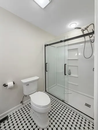 a bathroom with a toilet and a shower