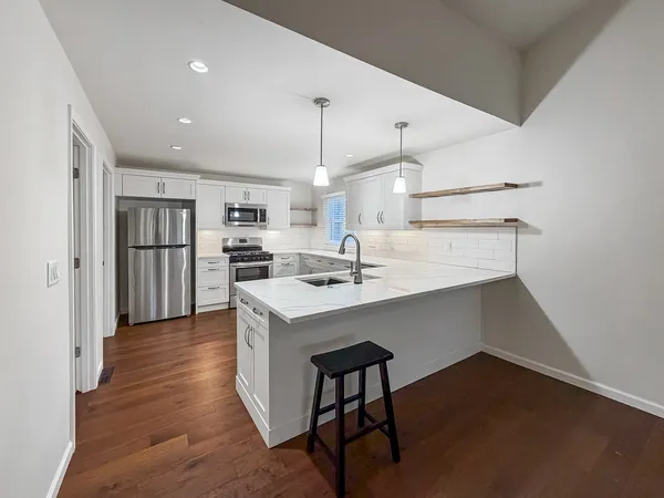 a kitchen with stainless steel appliances granite countertop a sink refrigerator and cabinets