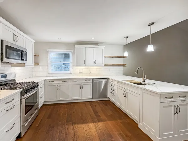 a kitchen with sink a stove and cabinets