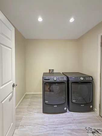 a utility room with wooden floor and washing machine