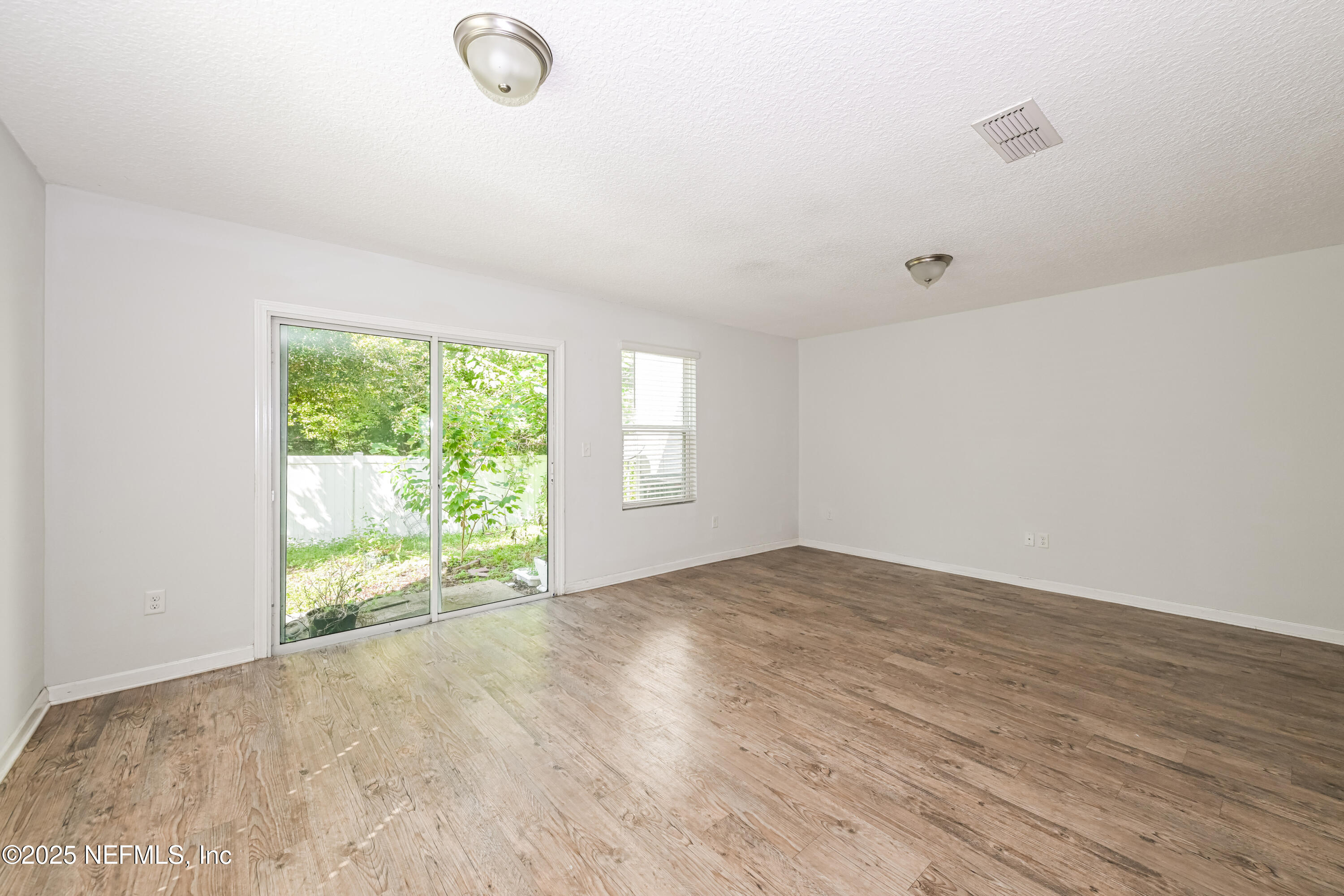 548 Eiseman Way Jacksonville, FL 32216 - Photo 2 of 15 an empty room with wooden floor and windows