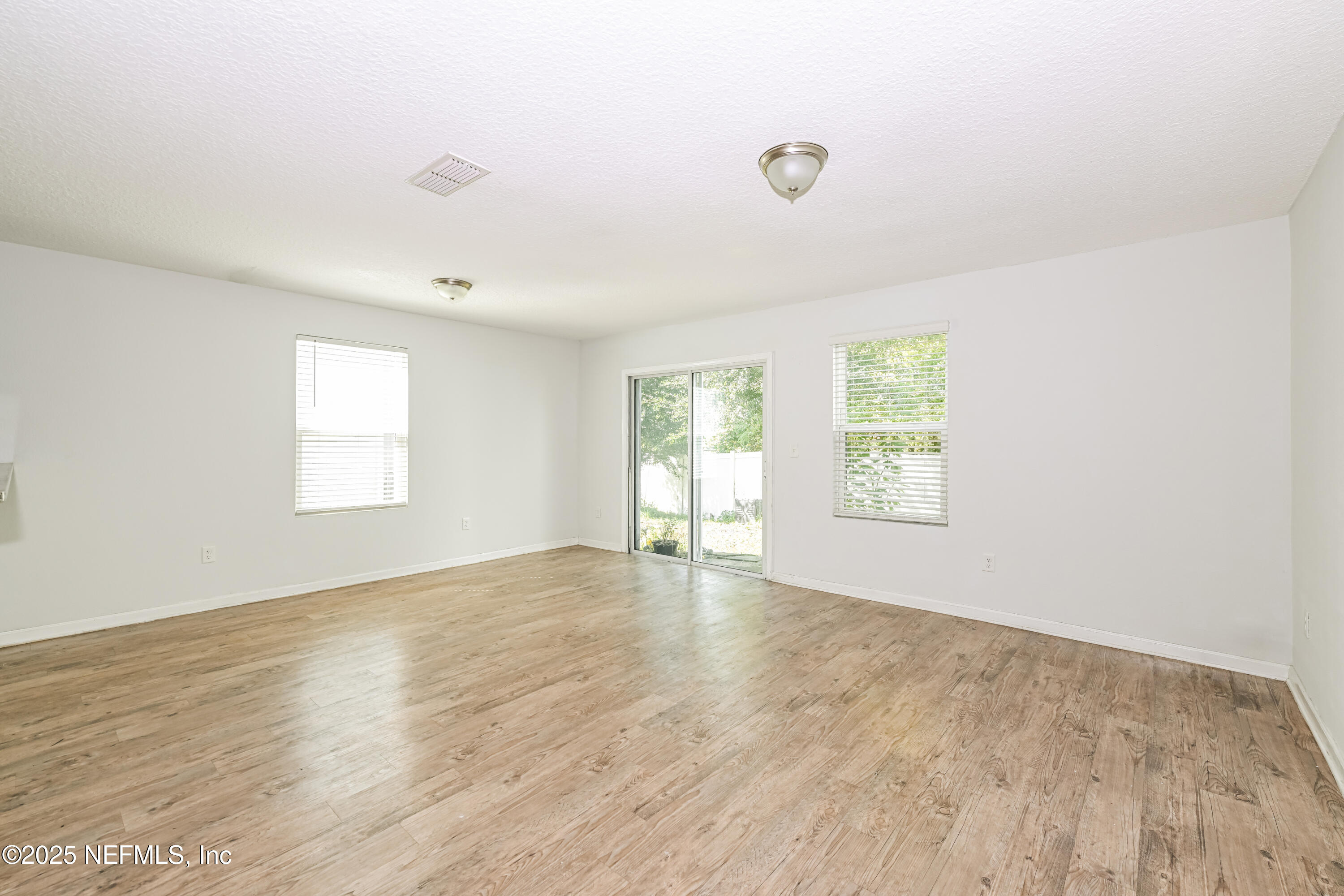 548 Eiseman Way Jacksonville, FL 32216 - Photo 3 of 15 an empty room with wooden floor and windows