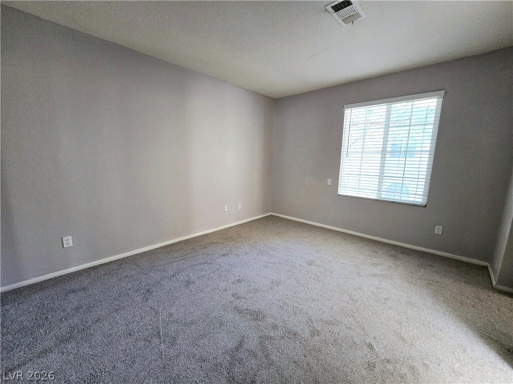 9325 West Desert Inn Road, Unit 229 Las Vegas, NV 89117 - Photo 8 of 17 Plush wall-to-wall carpeting and a wide window with integrated blinds anchor this versatile bedroom space.