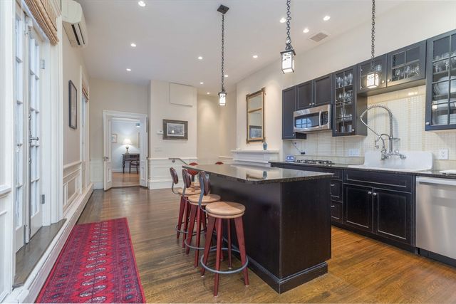 a kitchen with granite countertop a sink cabinets and wooden floor