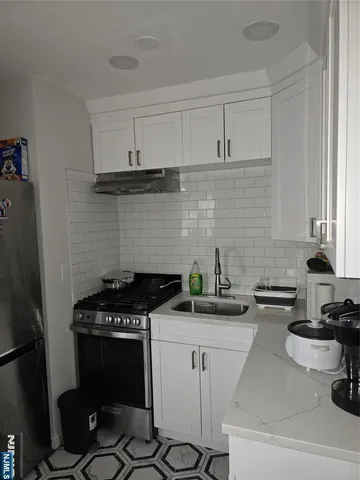 a kitchen with a stove a sink and cabinets
