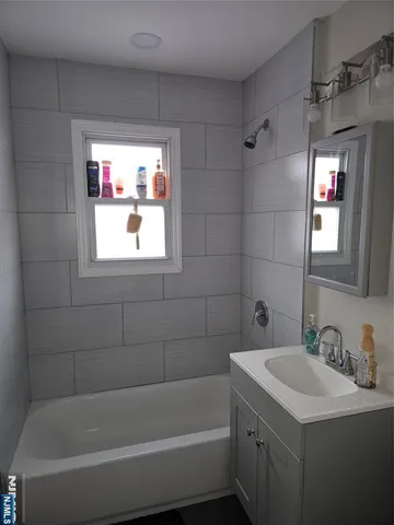a bathroom with a tub a sink and a window
