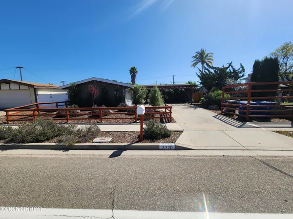 a view of a patio with a table and chairs under an umbrella