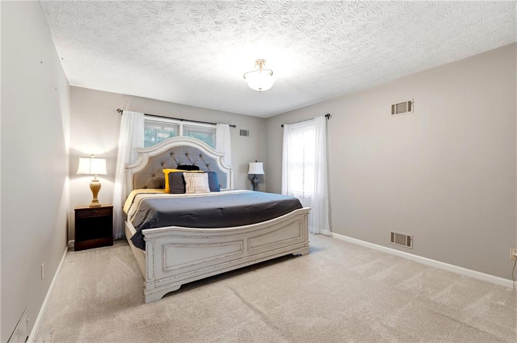 3121 Bonds Lake Road Northwest Conyers, GA 30012 - Photo 16 of 36 a bedroom with a bed and a chandelier