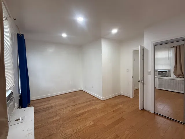 wooden floor in an empty room with a kitchen