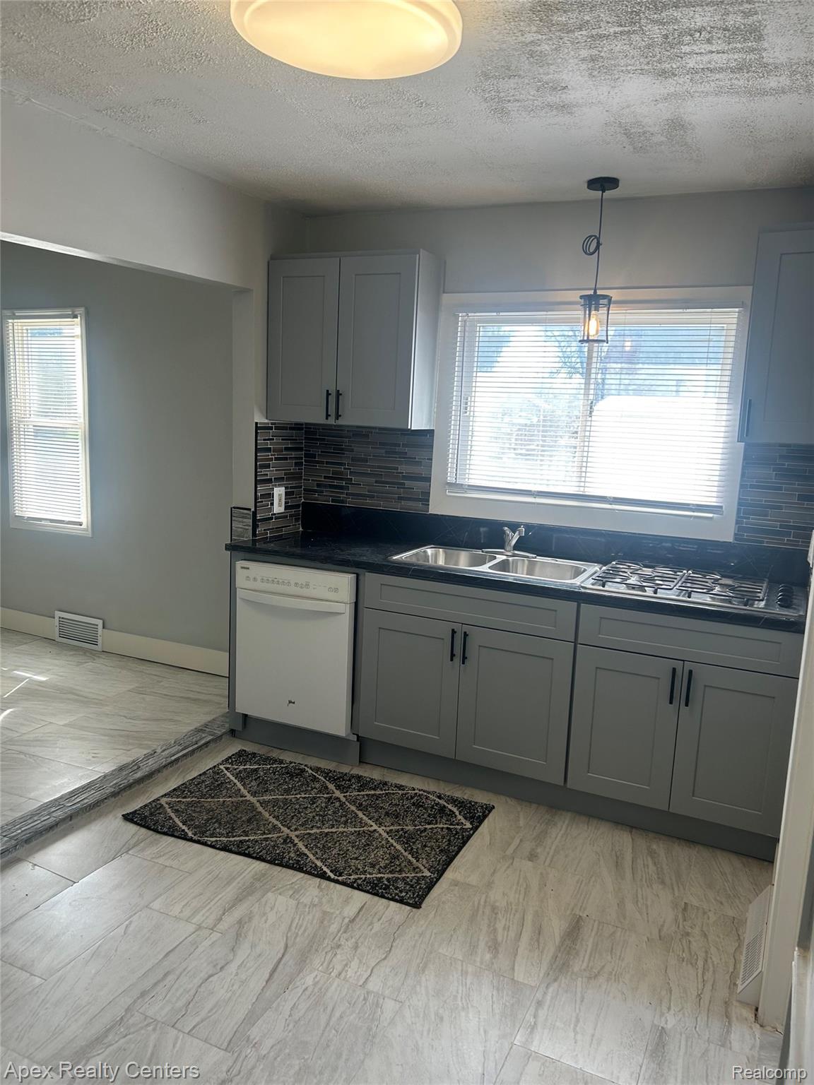 3158 Hickory Street Inkster, MI 48141 - Photo 5 of 15 Contemporary kitchen featuring gray cabinetry, dark countertops, and a full tile backsplash