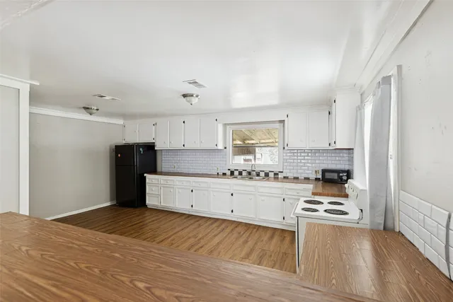a kitchen with white cabinets and appliances