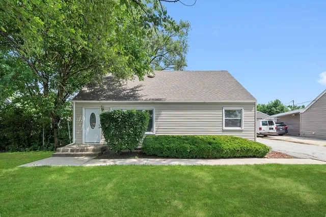 a view of a house with a yard and potted plants