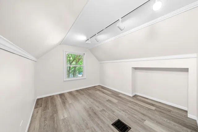 a view of empty room with wooden floor