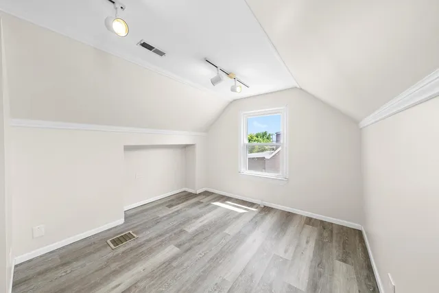 a view of empty room with wooden floor