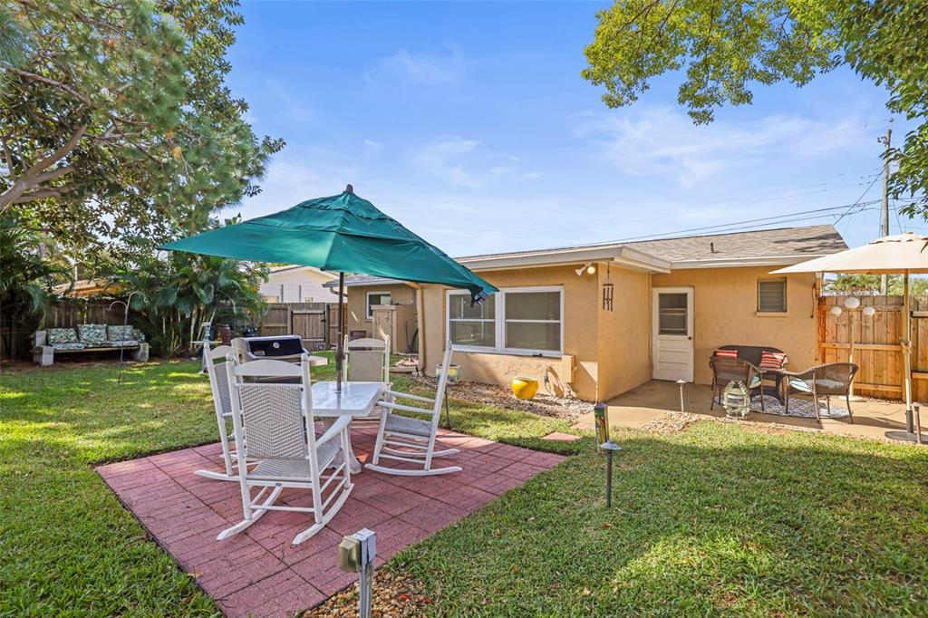 1215 Lazy Lake Road East Dunedin, FL 34698 - Photo 21 of 46 a patio table and chairs with a garden