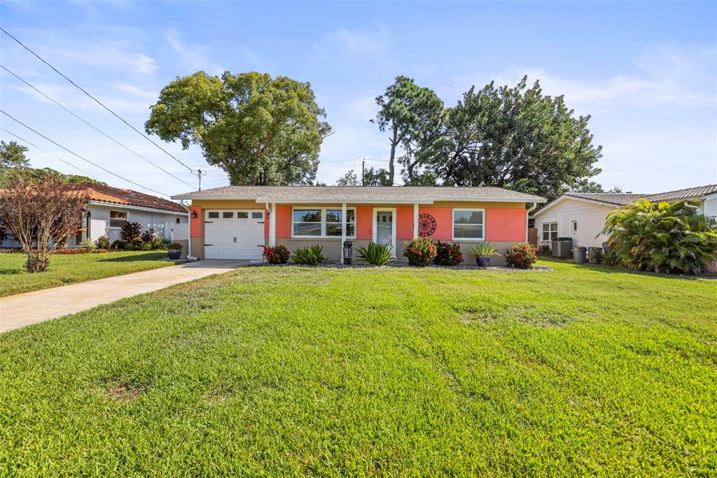 1215 Lazy Lake Road East Dunedin, FL 34698 - Photo 35 of 46 a front view of a house with yard and green space