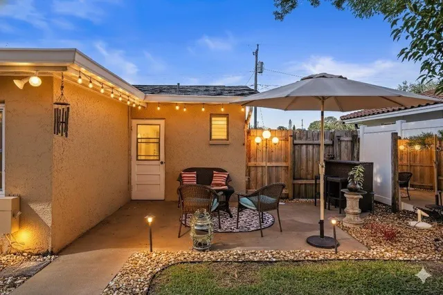 a view of a patio with table and chairs under an umbrella
